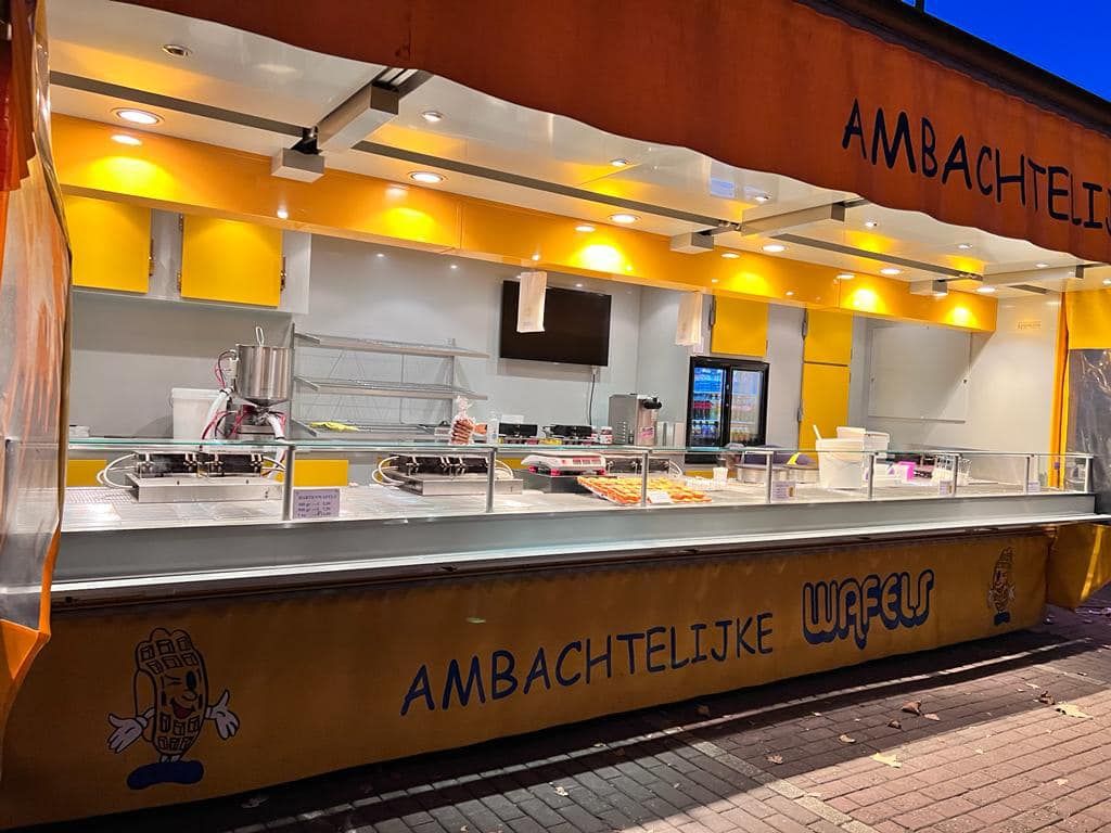 Het grote marktraam van Marcs Wafels tijdens de ochtendschemer waar onze wafels vers gebakken worden